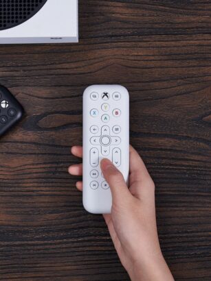 A hand holding a remote control Description automatically generated with medium confidence
