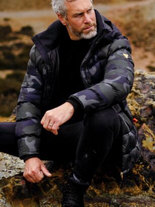 A person sitting on a rock Description automatically generated