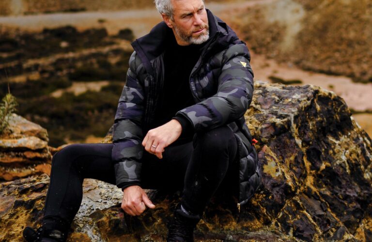 A person sitting on a rock Description automatically generated