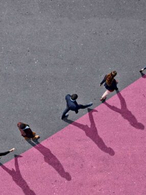 line of people walk along upward-curving line